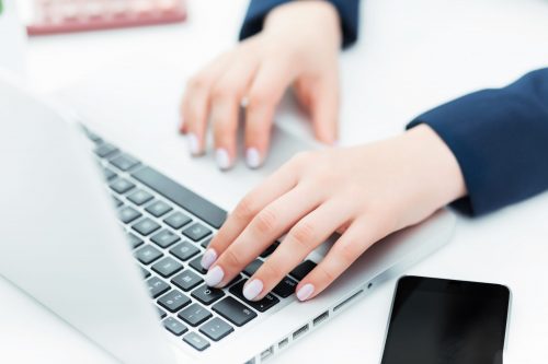 The hands of woman on the keyboard of her laptop computer